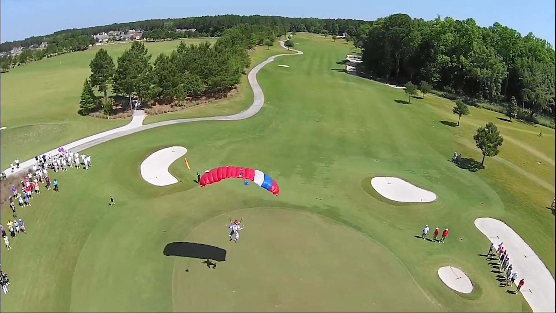 Aerial view of tandem skydivers landing on the 9th green