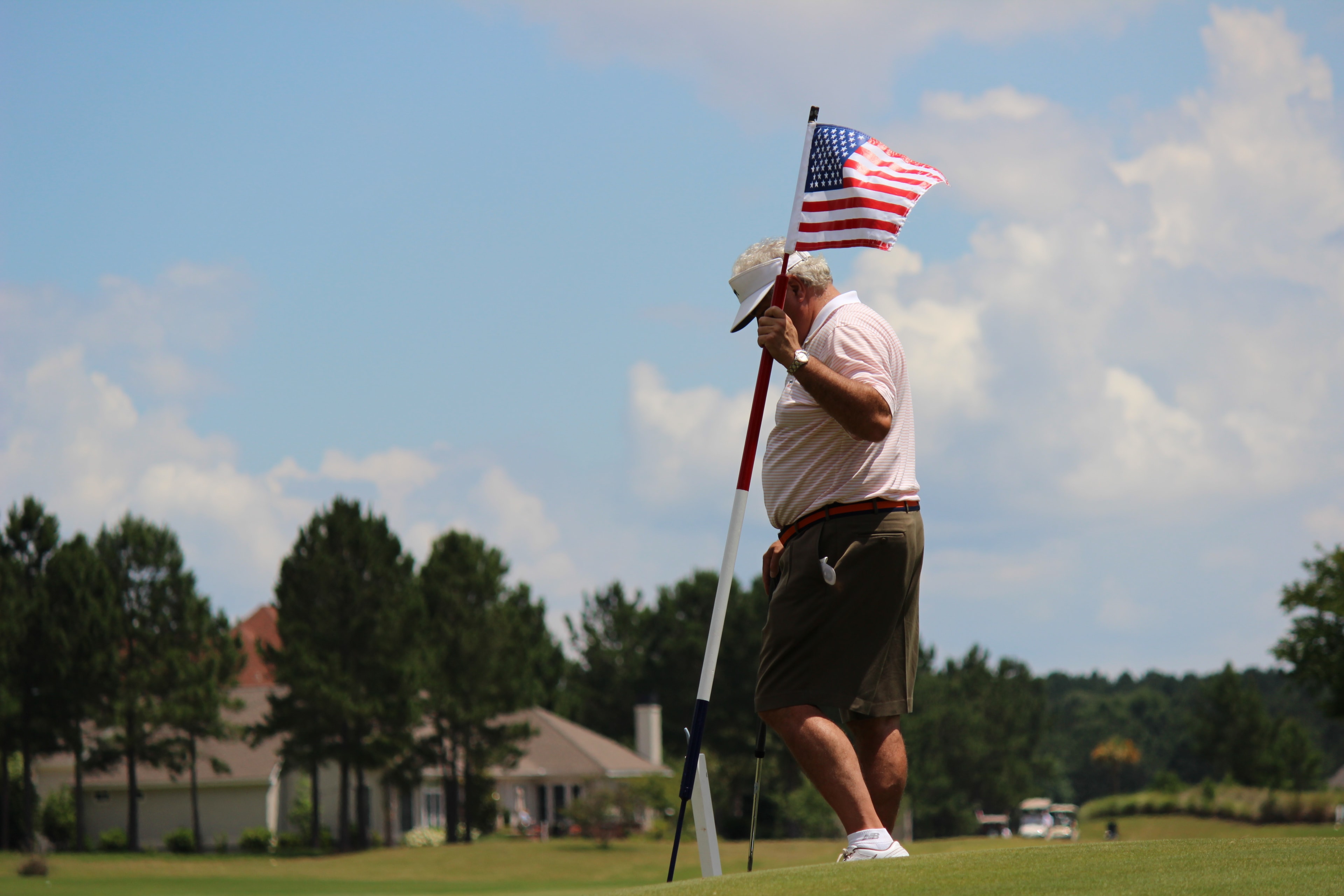 Golfer holding an American flag pin at the Golf Classic