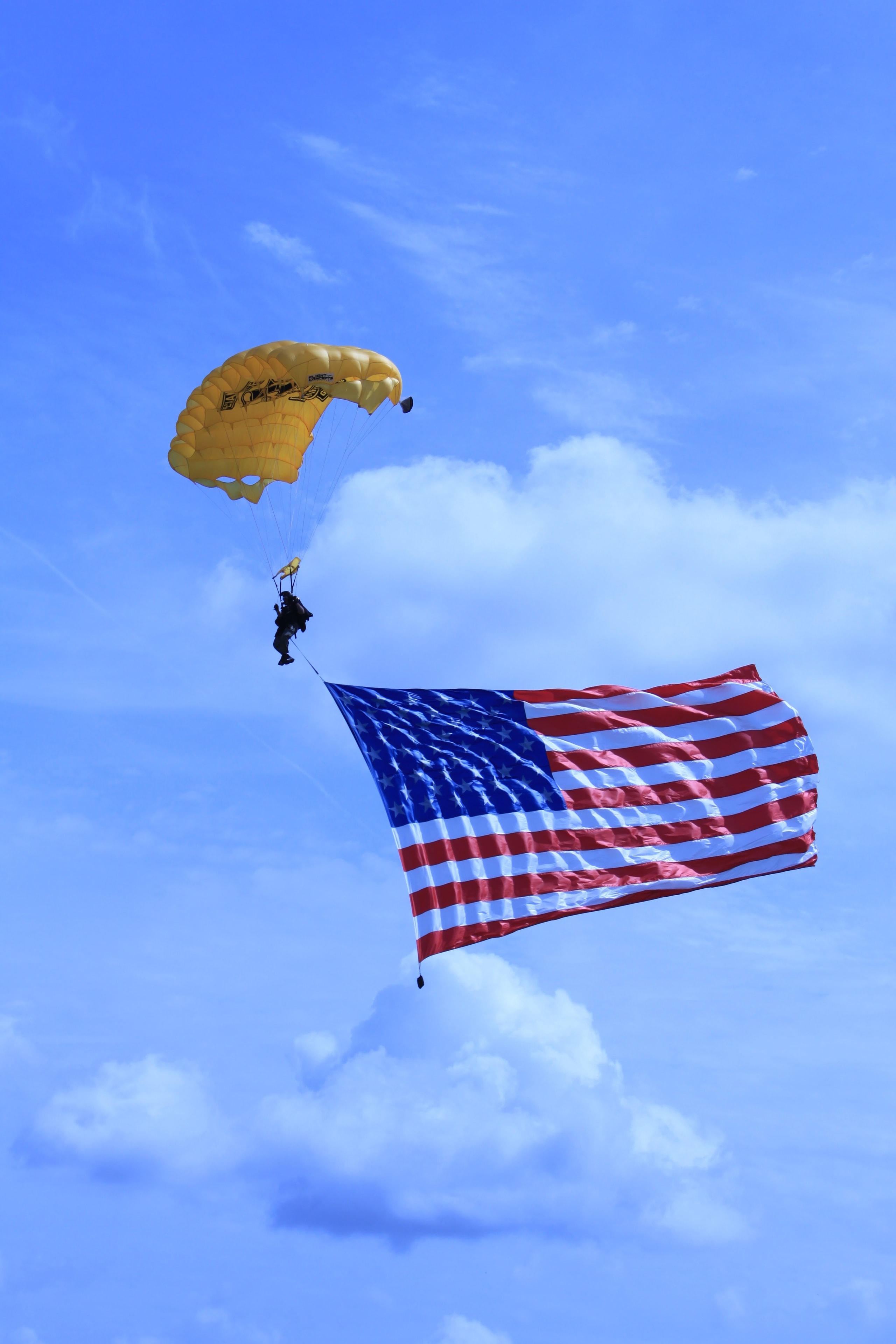 Skydiver carrying a large American flag at the Golf Classic